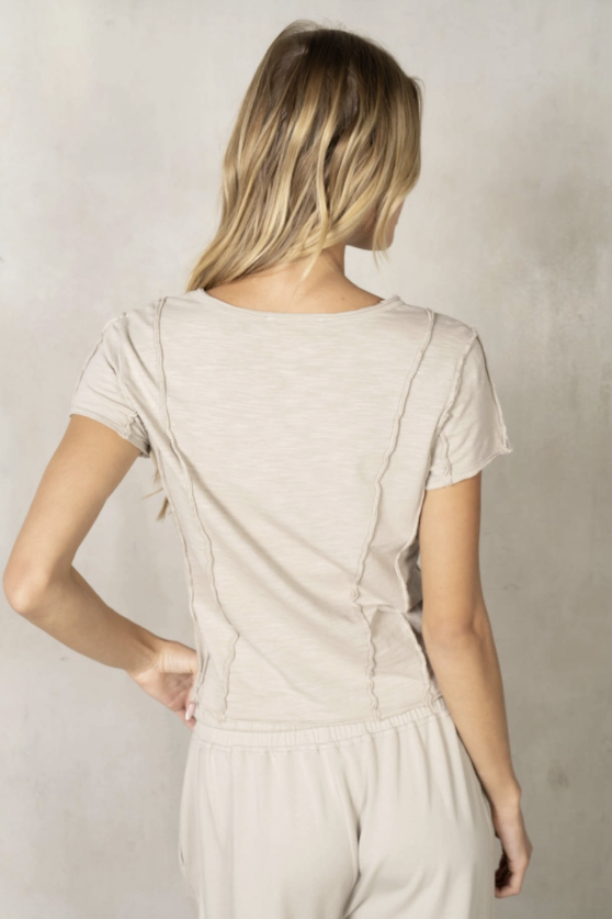 Woman wearing a beige outfit against a plain background
