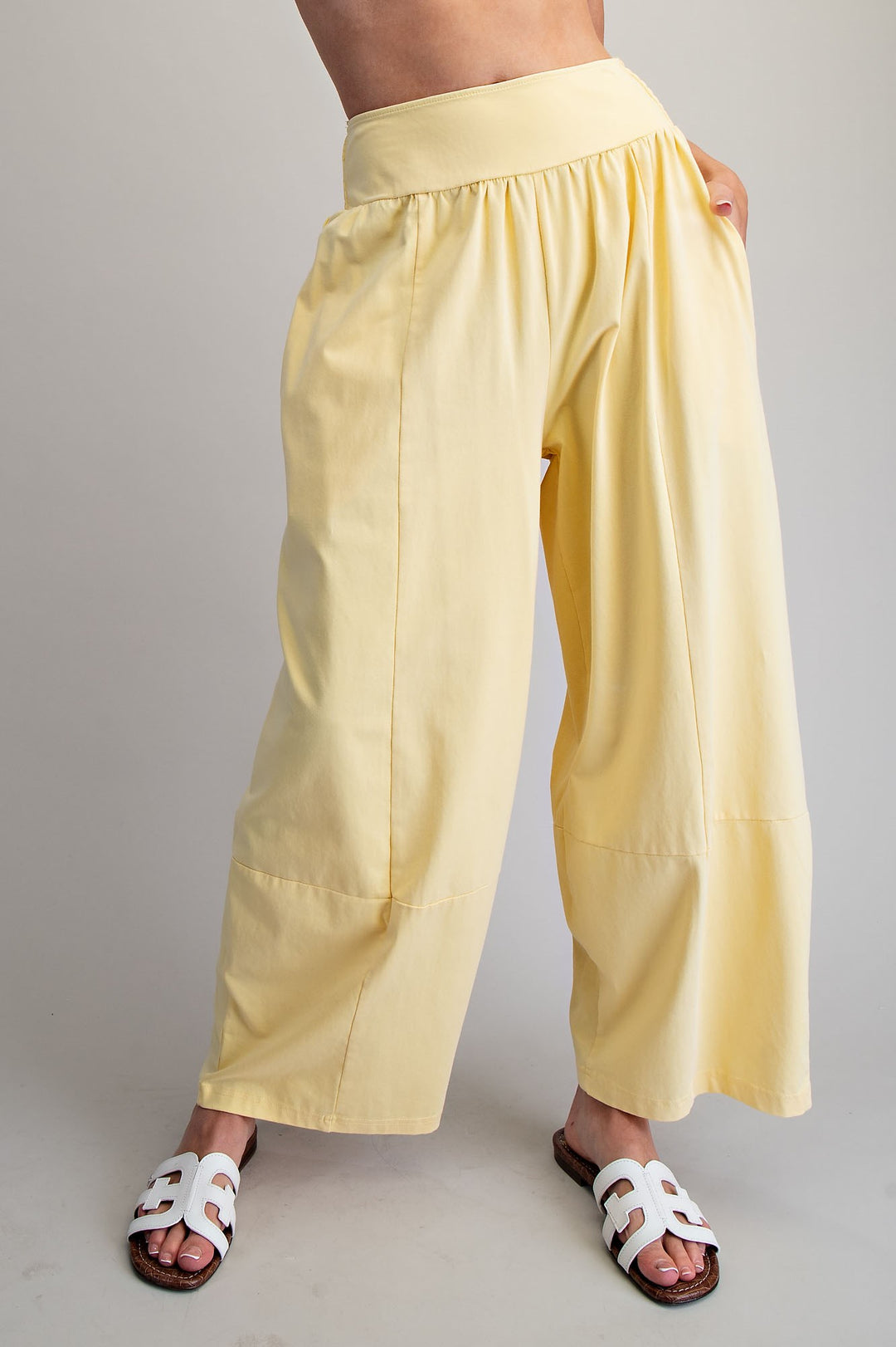 Yellow wide-leg pants worn by a person on a plain background