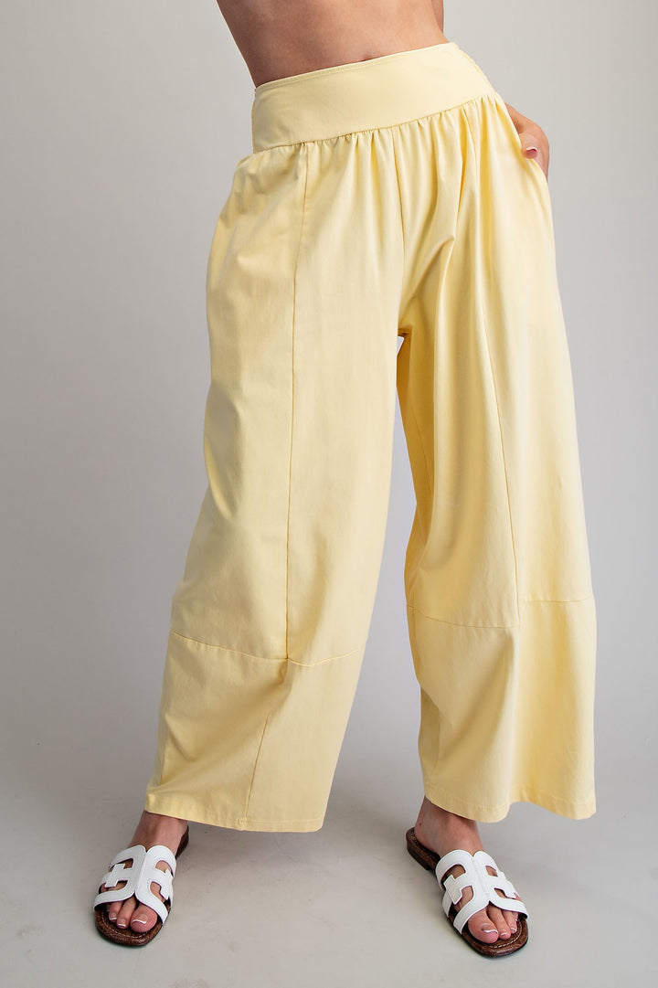 Yellow wide-leg pants worn by a person on a plain background
