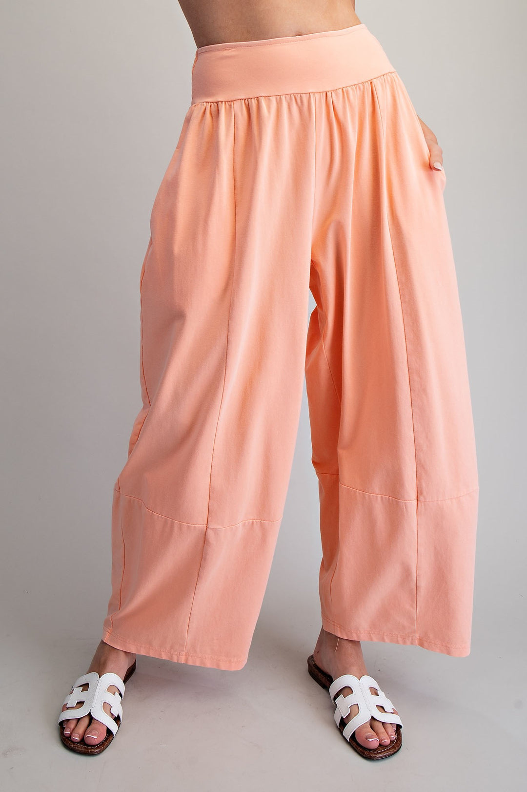 Person wearing peach-colored wide-leg pants on a plain background