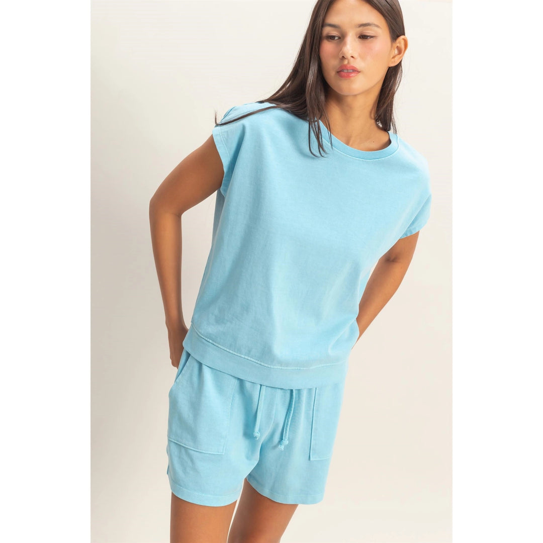 Woman wearing a light blue outfit on a plain background