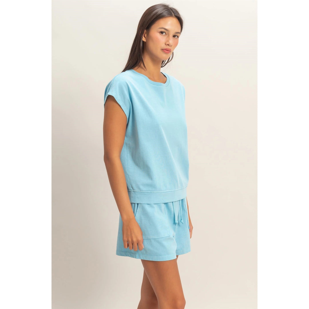 Woman wearing a light blue outfit on a plain background