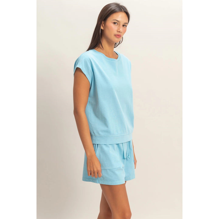 Woman wearing a light blue outfit on a plain background