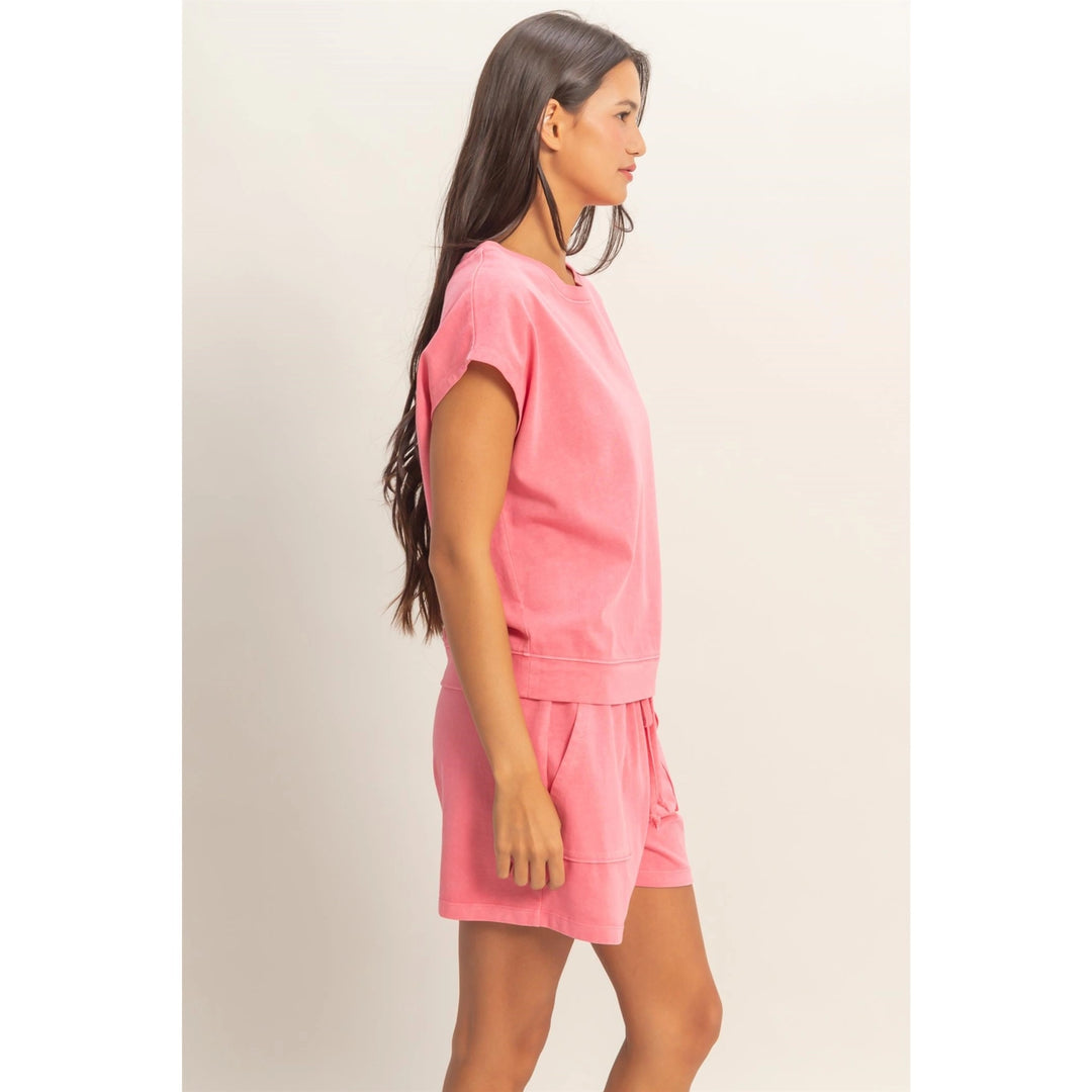 Woman wearing a pink outfit on a plain background