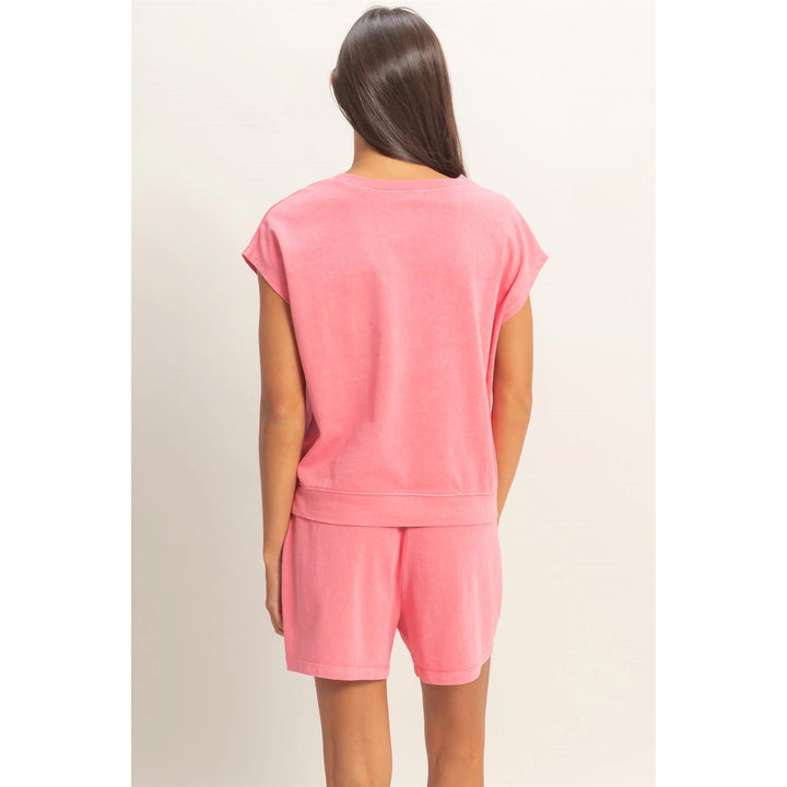 Person wearing a pink outfit on a plain background