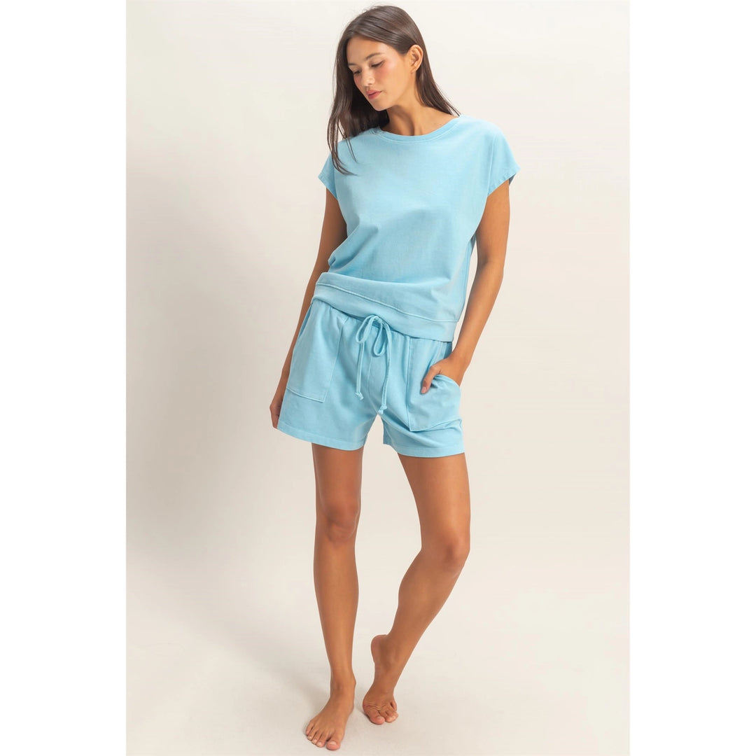 Woman wearing a light blue pajama set on a plain background