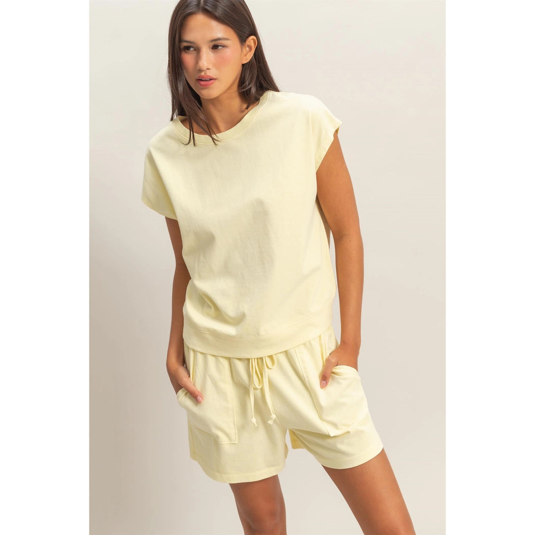 Woman wearing a light yellow outfit on a plain background