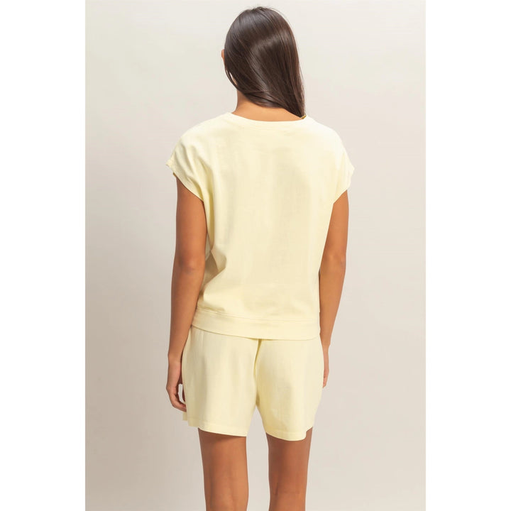 Person wearing a light yellow outfit on a plain background