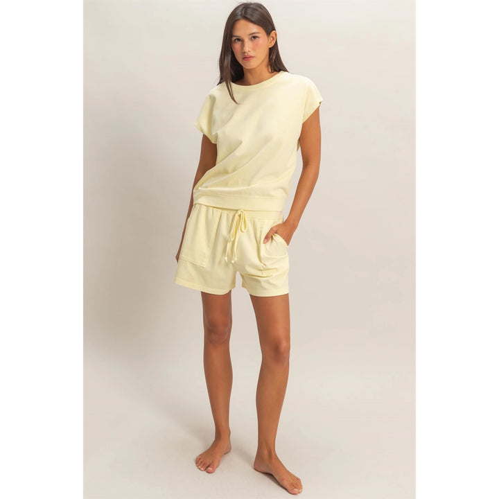 Woman wearing a light yellow outfit on a plain background