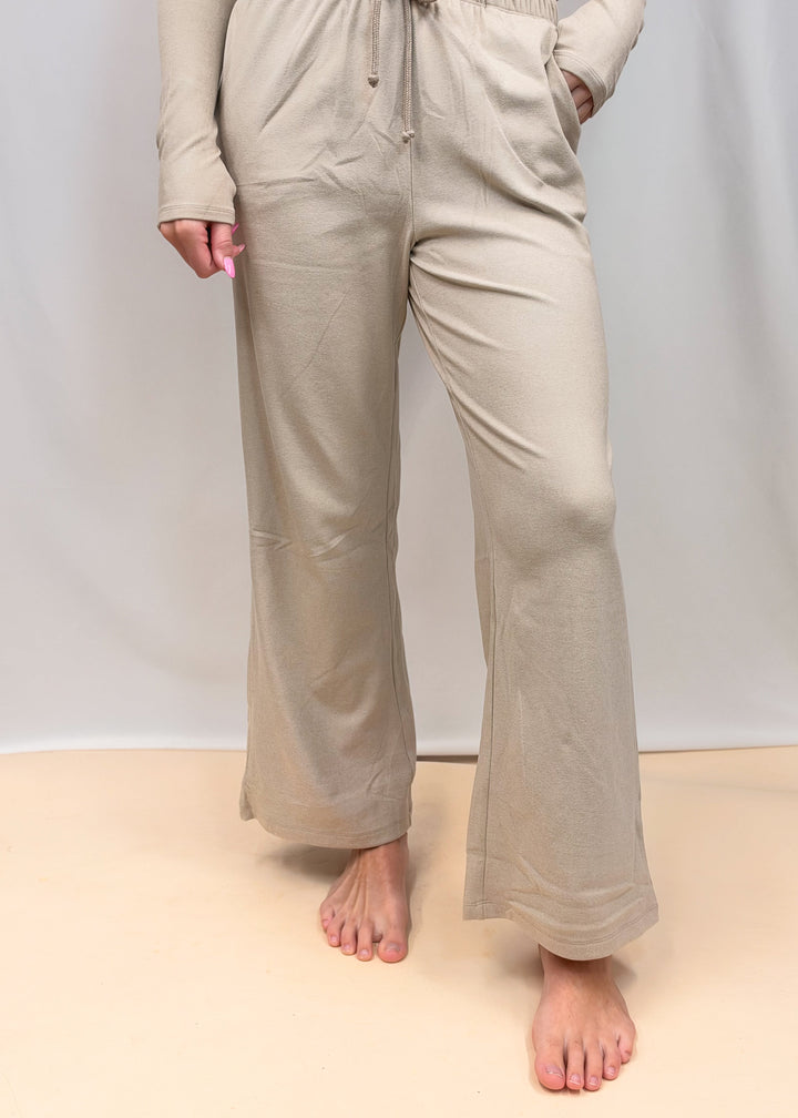 Woman shown from waist down wearing matching taupe set on plain background