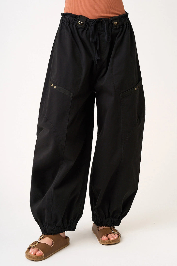 woman wearing black pants on plain background