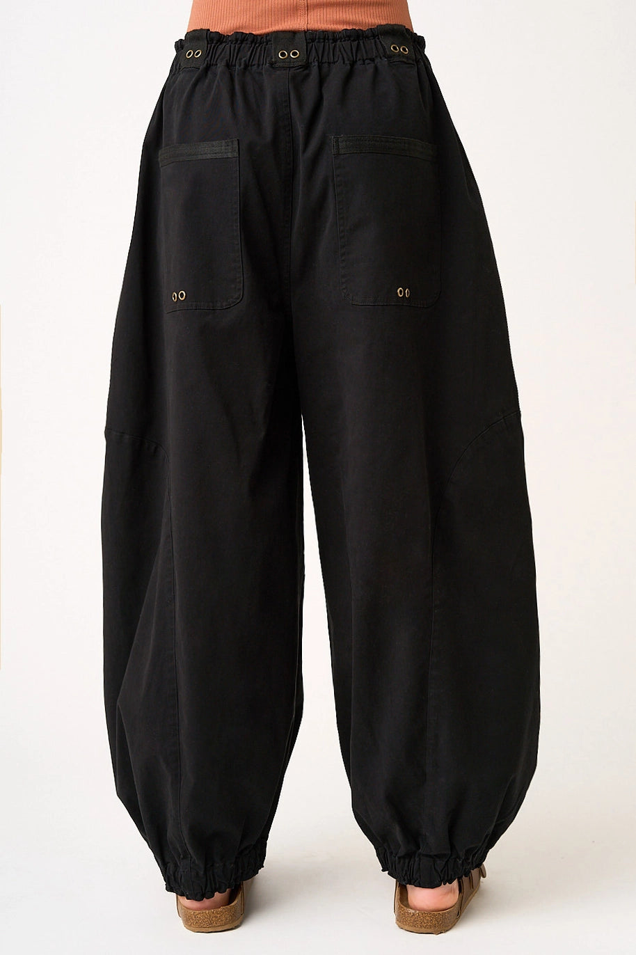 woman wearing black pants on plain background