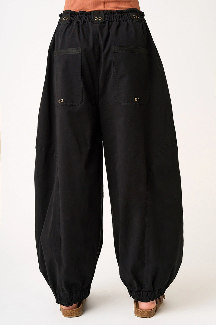 woman wearing black pants on plain background