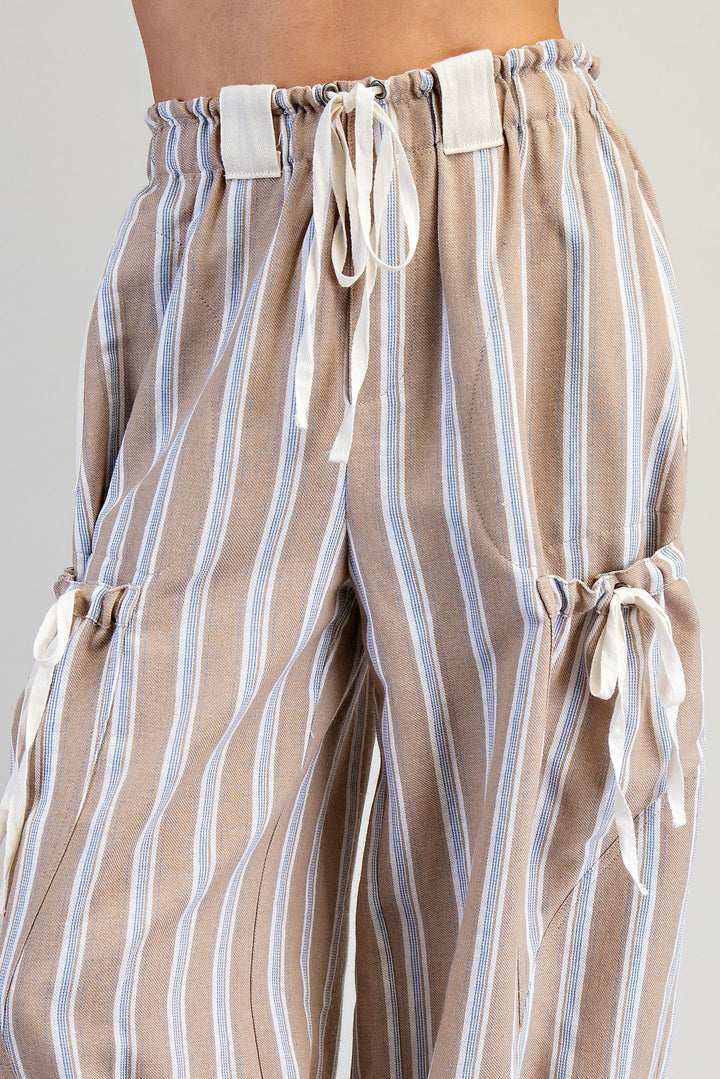 Striped pants with drawstring details on a plain background