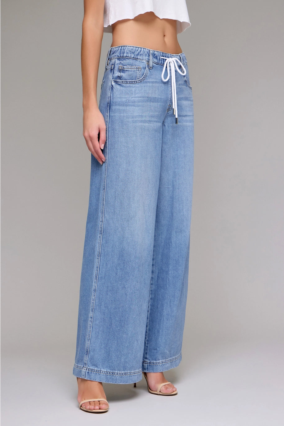 Wide-leg jeans worn by a person on a plain background