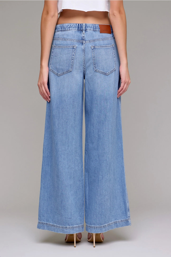 Wide-leg jeans worn by a person on a plain background