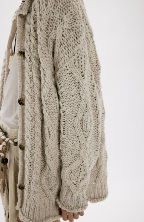 Woman wearing beige cardigan on white background
