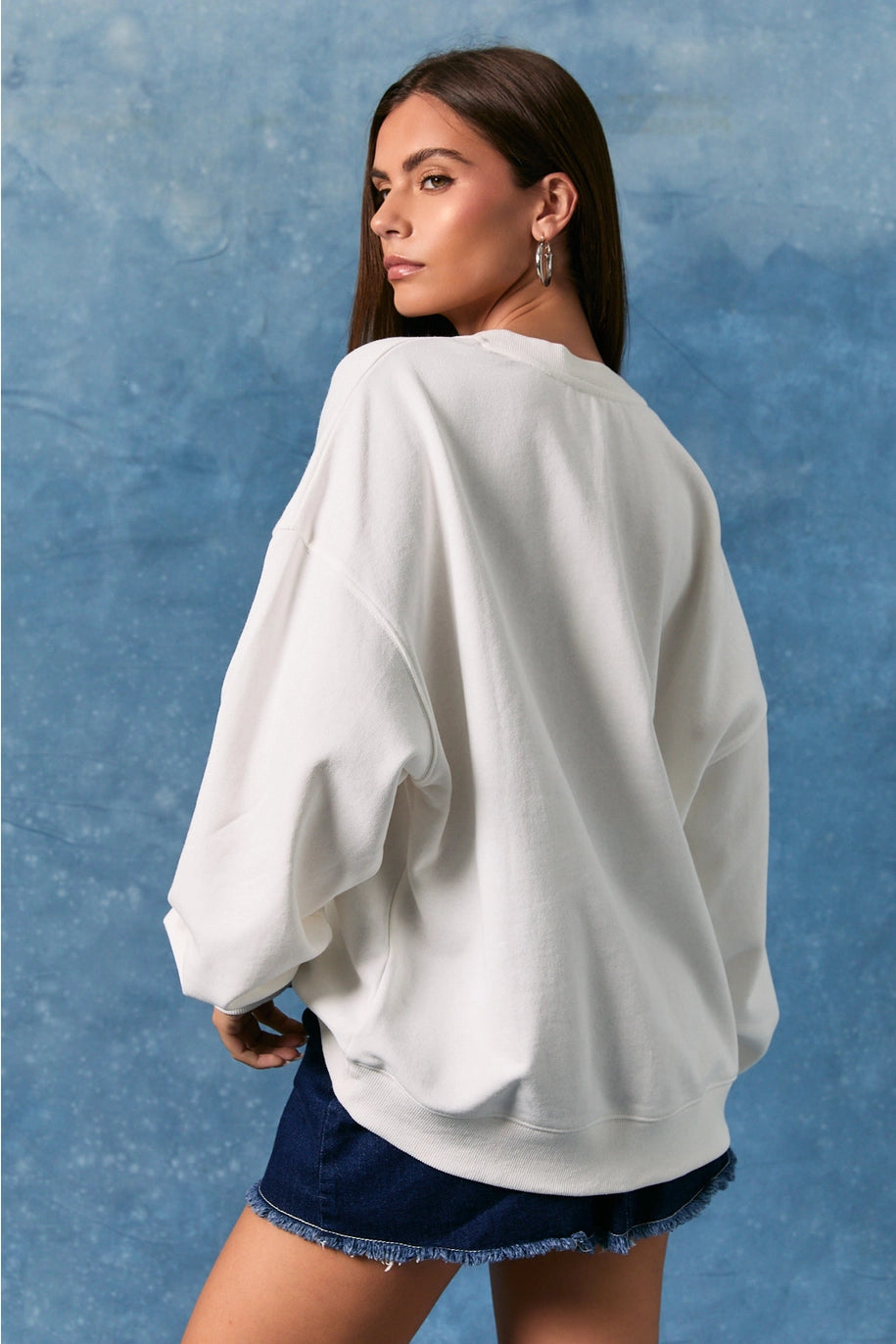 Back of woman wearing white sweatshirt on plain background