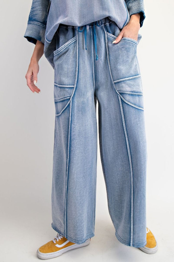 Person wearing light blue denim pants with a plain background