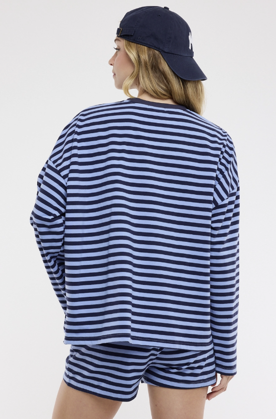 Person wearing a blue and white striped outfit with a navy cap on a white background