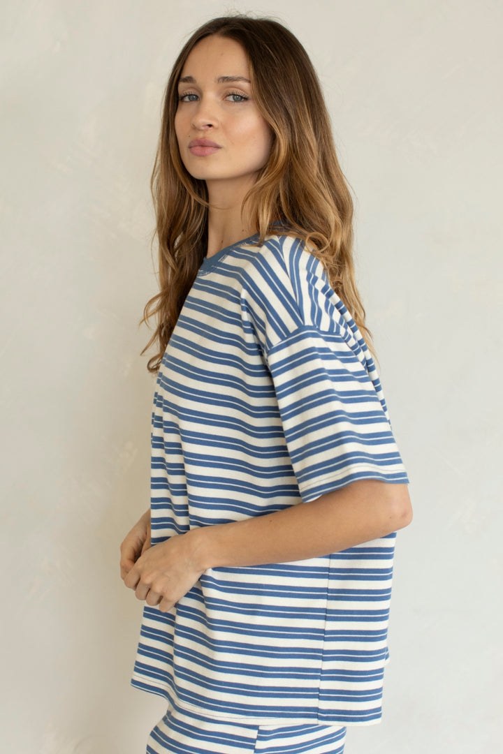 Woman wearing blue and white stripe set on plain background