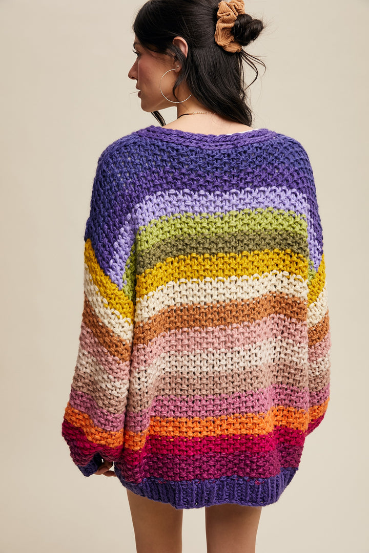 Person wearing a colorful striped sweater against a beige background