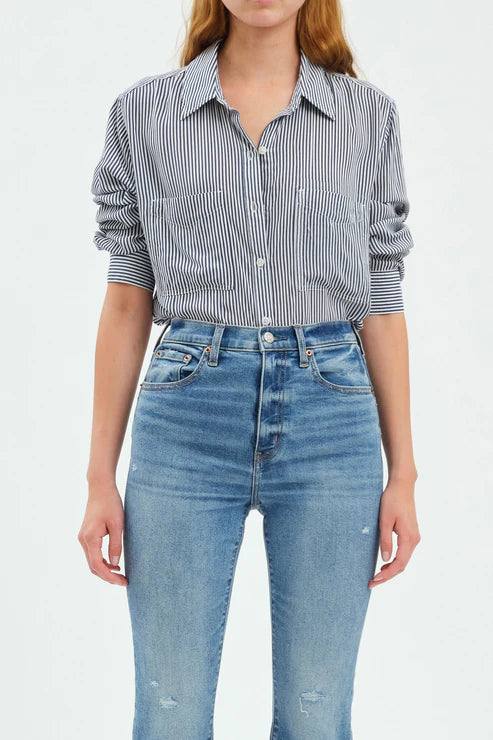 Person wearing a striped shirt and blue jeans on a white background
