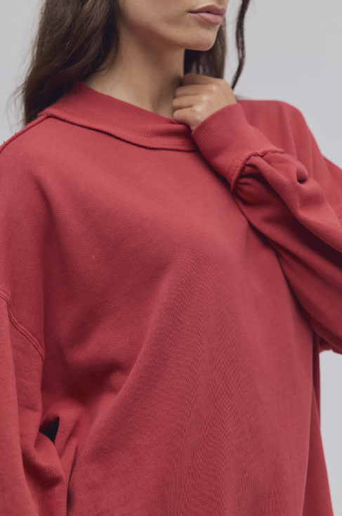 Close up of woman wearing red mock neck sweatshirt on white background