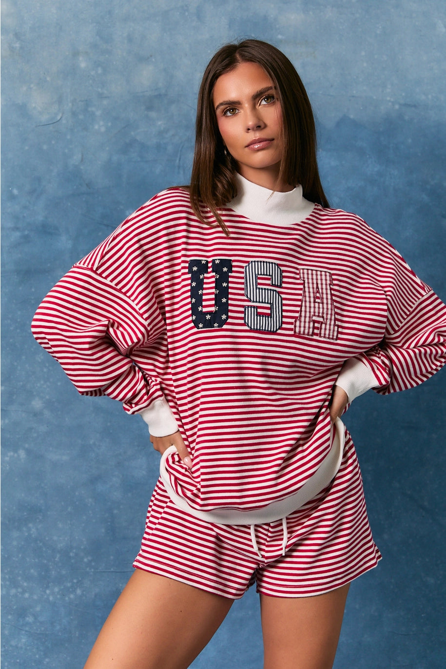 Woman wearing matching red and white stripe top and bottoms on blue background