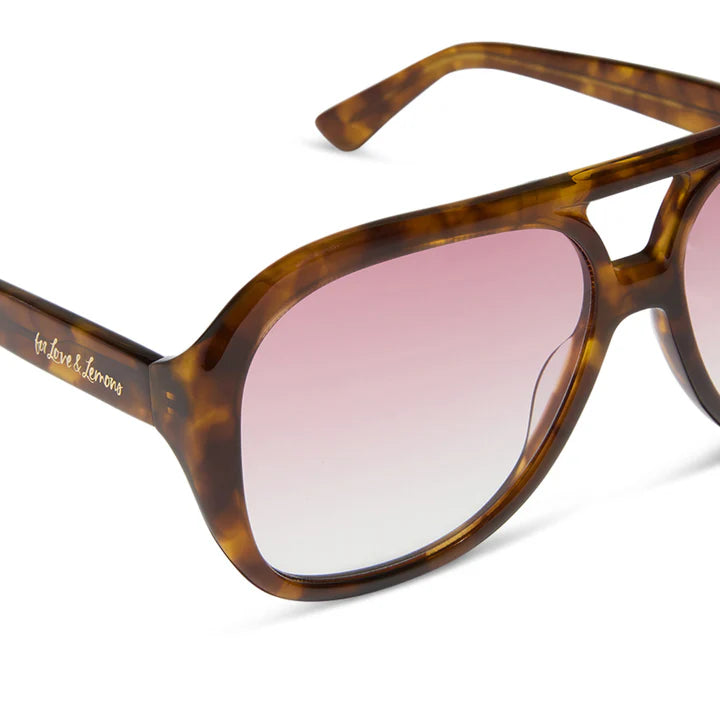 Sunglasses with tortoiseshell frame and pink gradient lenses on a white background