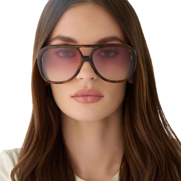 Woman wearing a pair of sunglasses with a white background