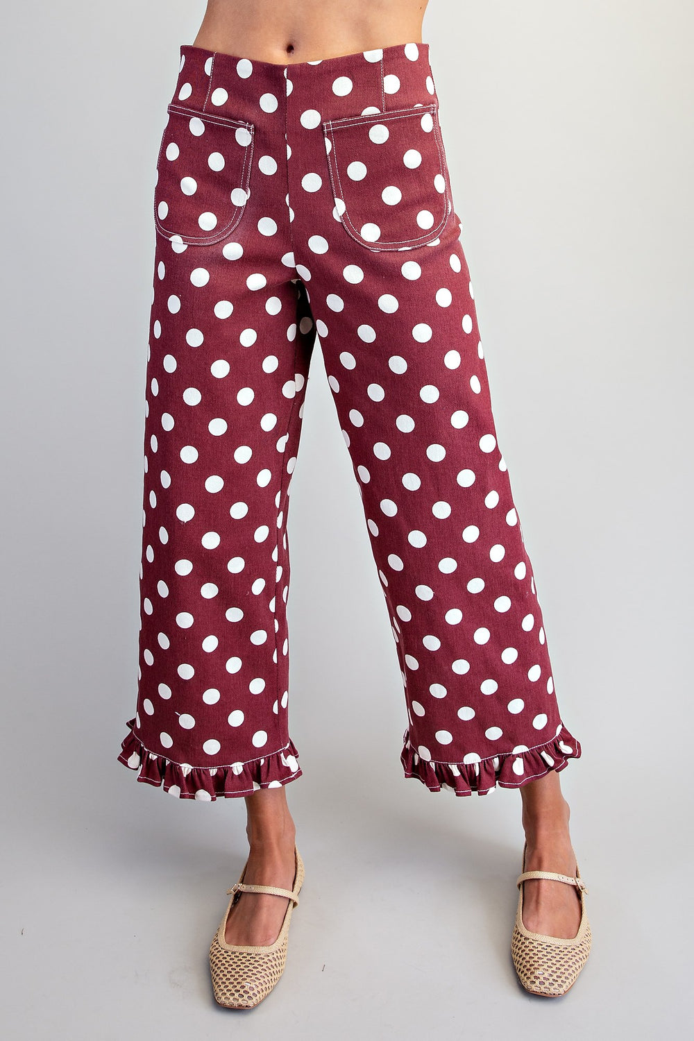 Maroon pants with white polka dots on a plain background