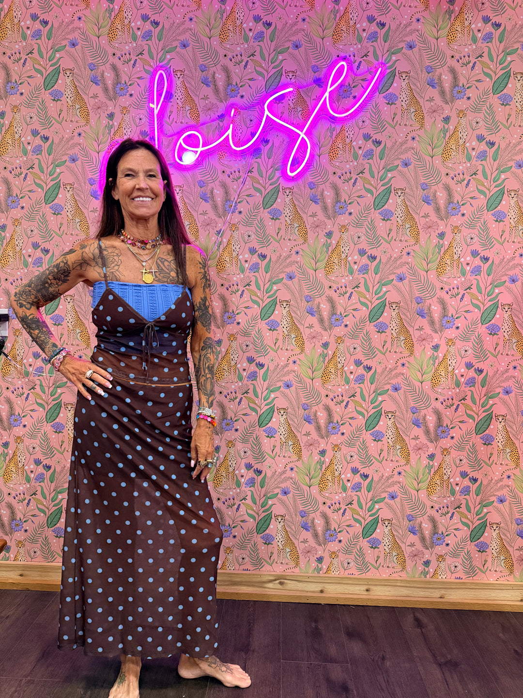 Woman wearing brown and blue polka dot matching set on pink floral background