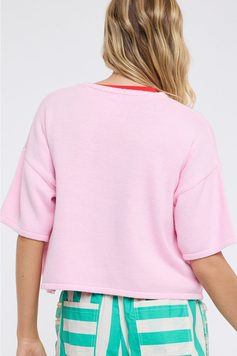 Person wearing a pink t-shirt and green striped pants on a white background