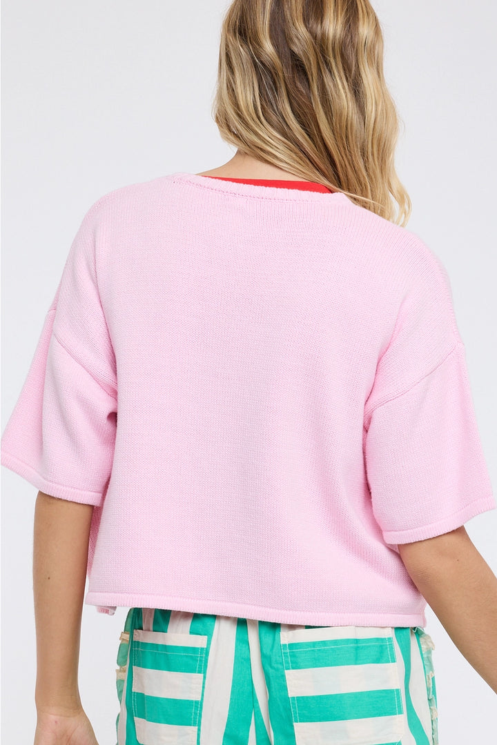Person wearing a pink t-shirt and green striped pants on a white background