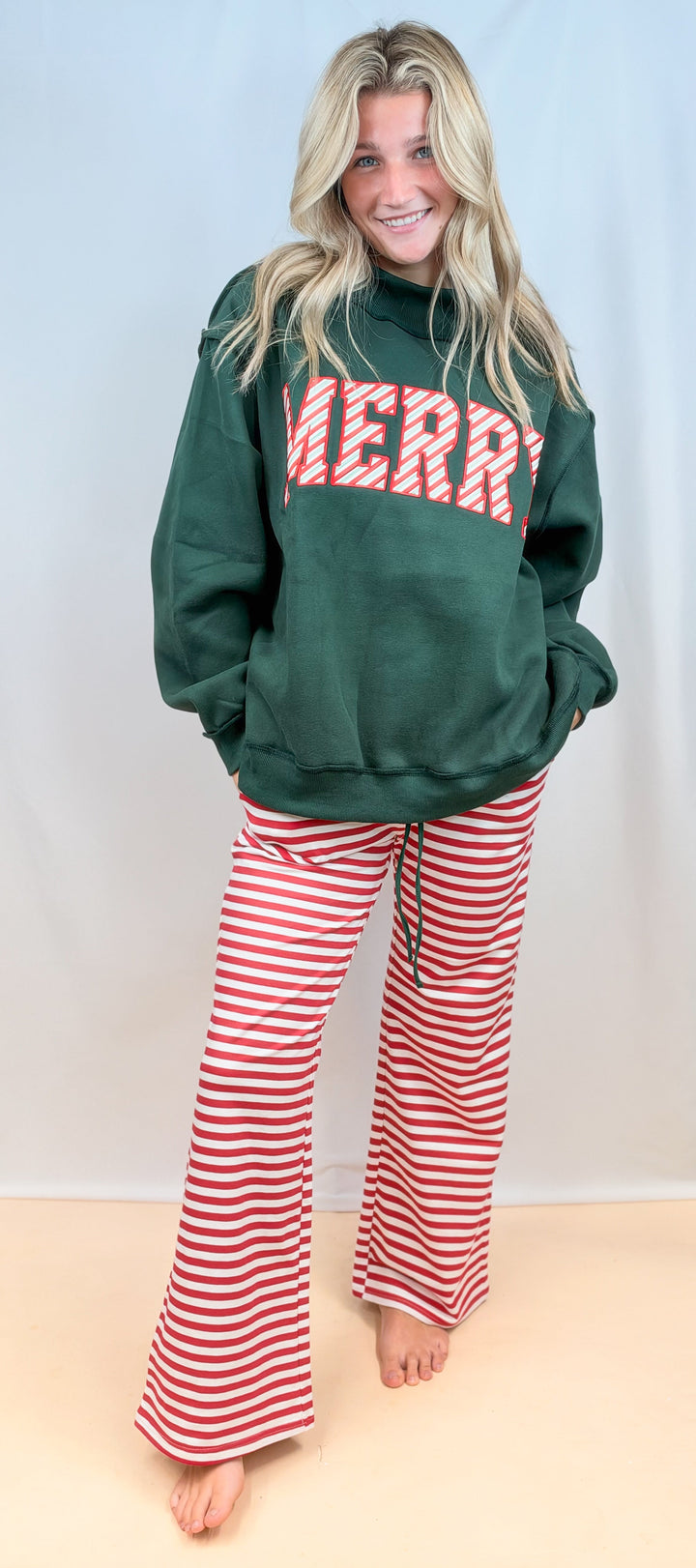 Woman wearing green mock neck sweatshirt with &