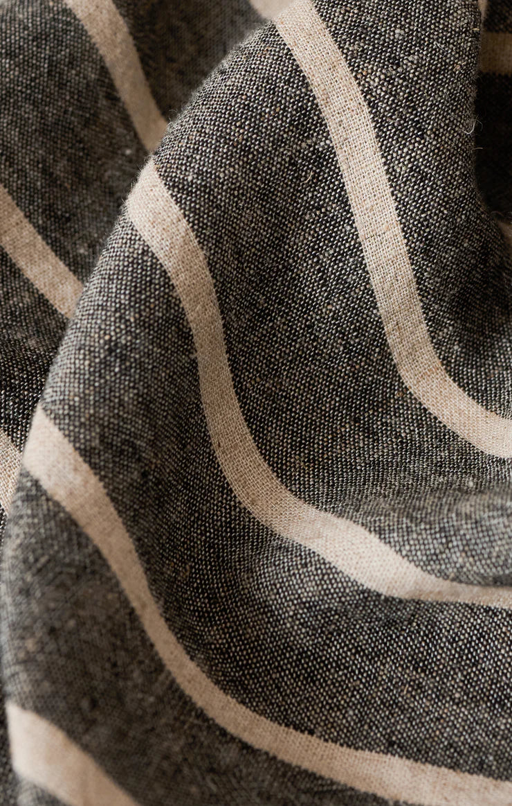 Close-up of textured fabric with beige lines on a dark background