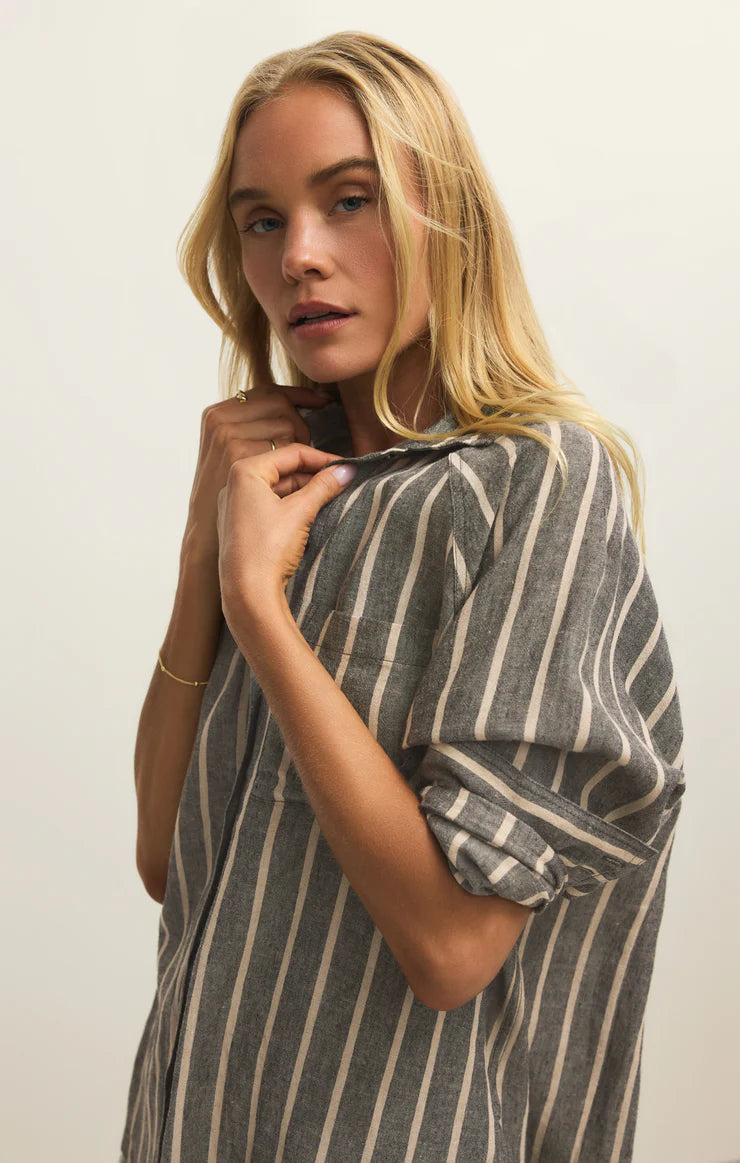 Woman wearing a striped dress against a plain background