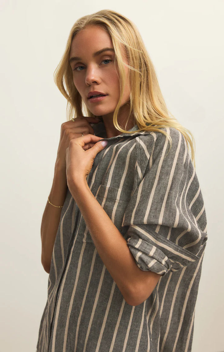 Woman wearing a striped dress against a plain background