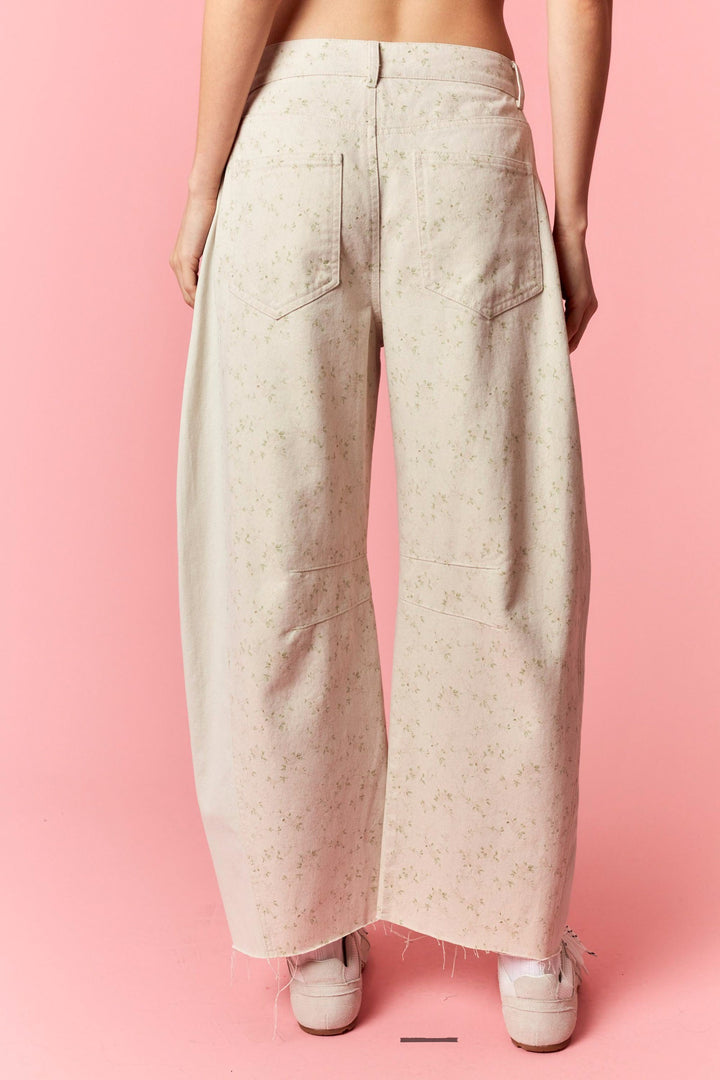 Beige wide-leg pants worn by a person on a pink background