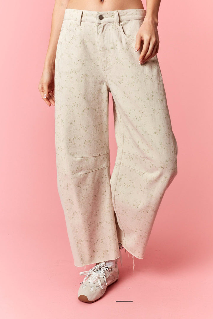 Person wearing light-colored wide-leg pants on a pink background