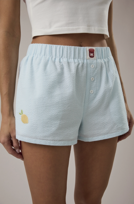 Light blue embroidered shorts worn by a woman on a plain background