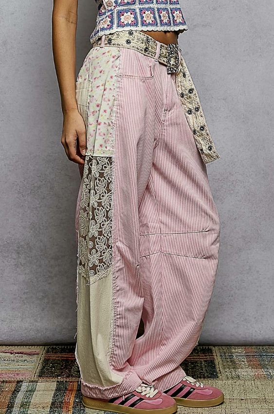 Person wearing pink striped pants with floral and geometric patterns on a gray background