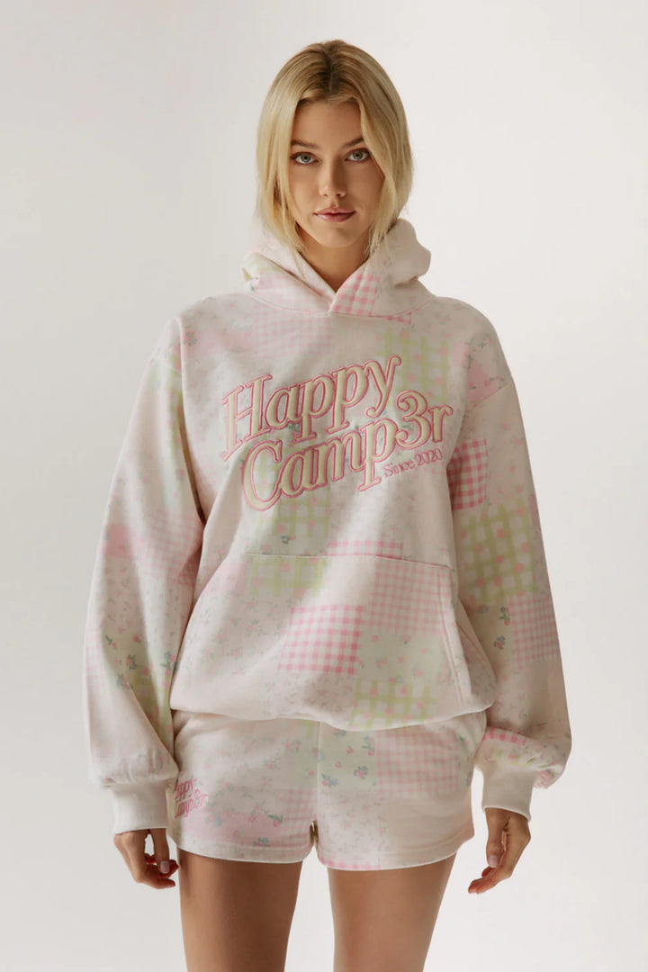 Woman wearing pink patchwork hoodie on white background