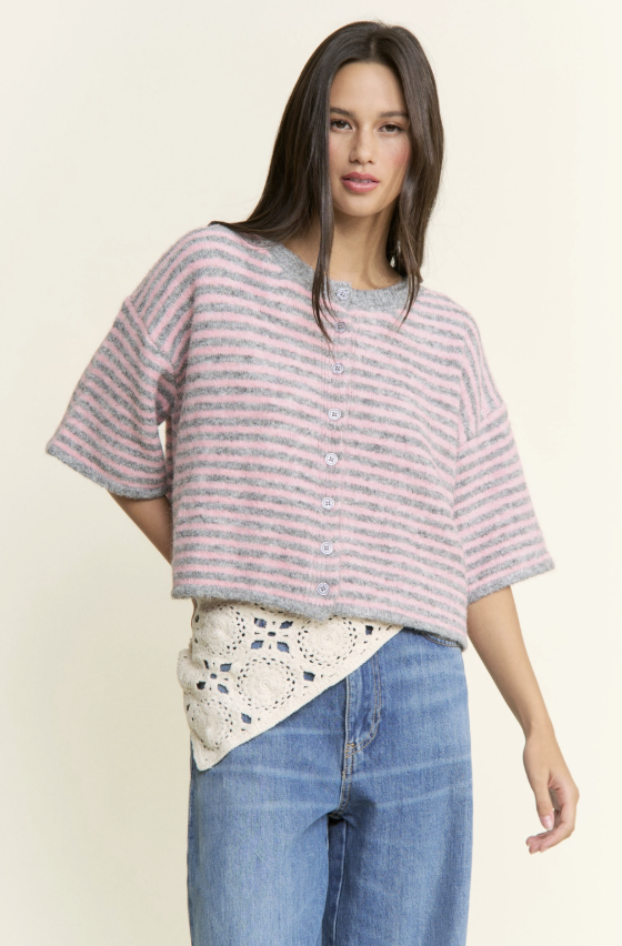 Woman wearing a striped shirt and jeans on a plain background