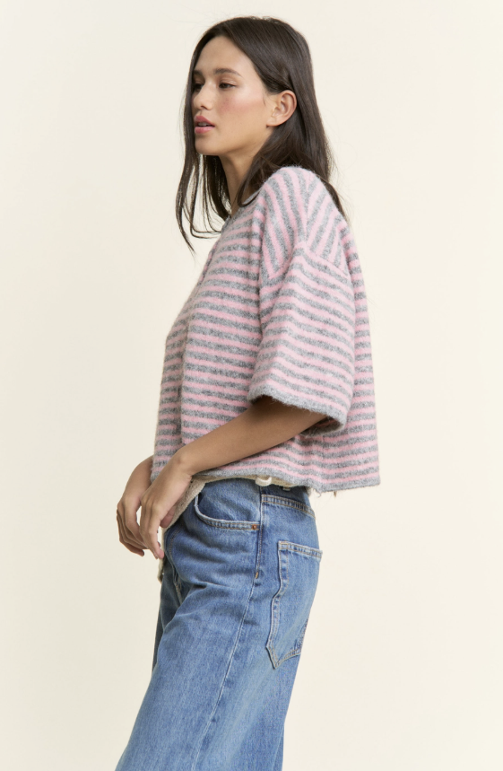 Woman wearing a striped shirt and jeans on a plain background