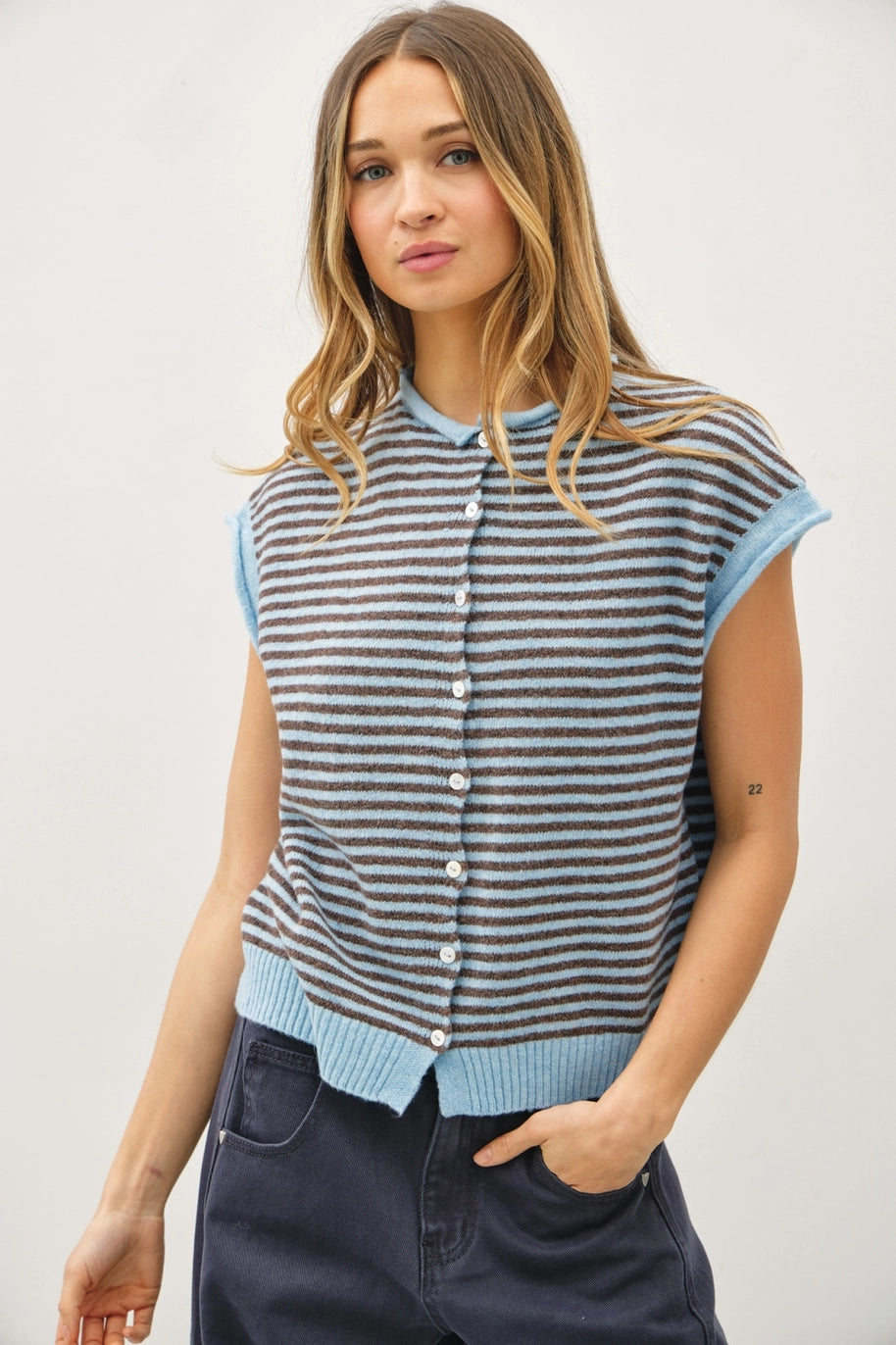 Woman wearing a striped sleeveless cardigan against a plain background