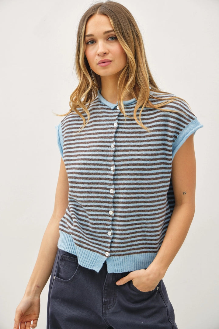 Woman wearing a striped sleeveless cardigan against a plain background