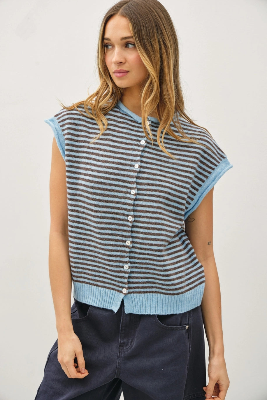 Woman wearing a striped sleeveless cardigan with buttons on a plain background