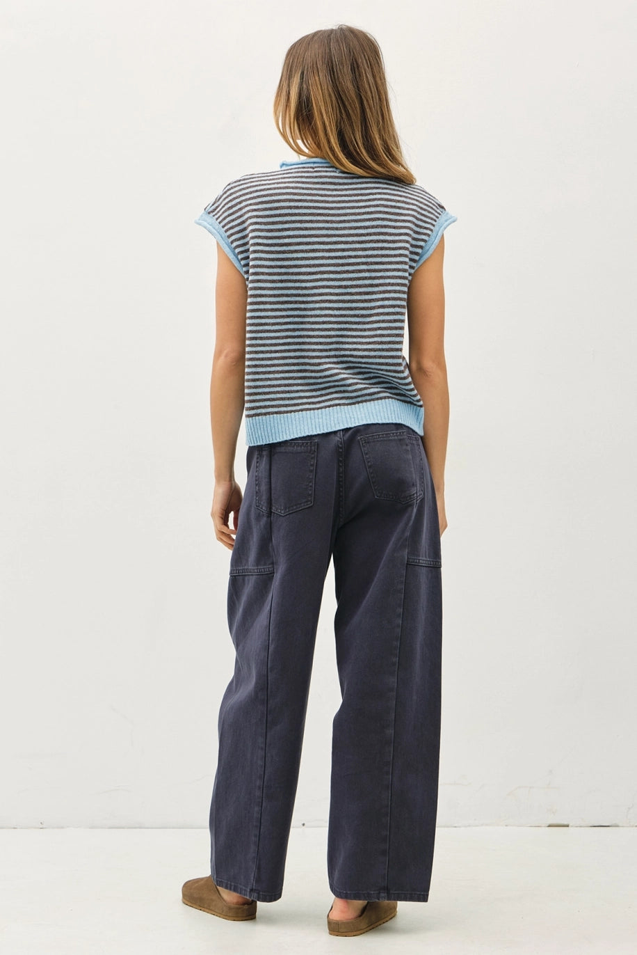 Woman wearing a striped shirt and dark pants on a white background